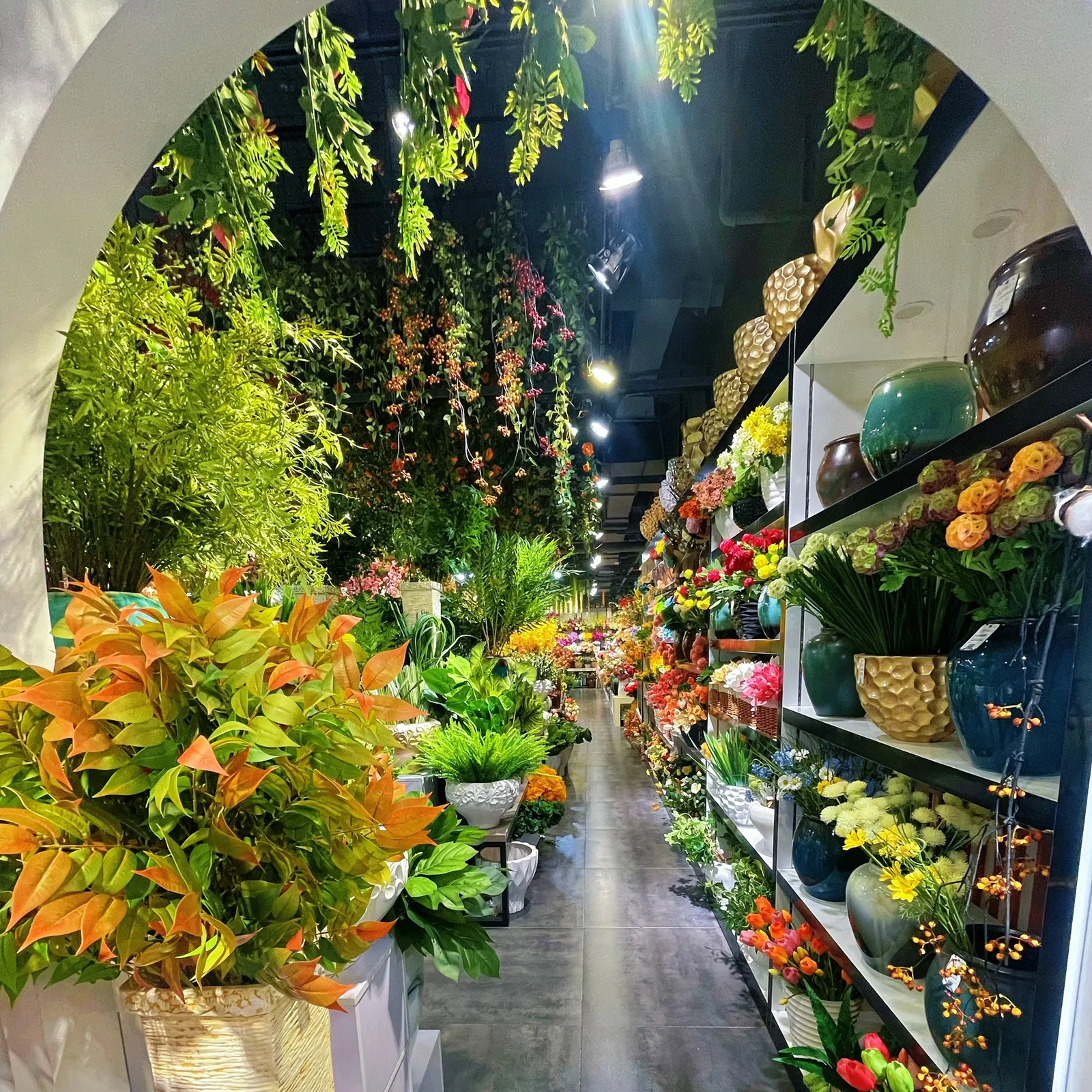 Artificial plant and greenery warehouse aisle with ceramic vase displays at PJTL factory, Shantou