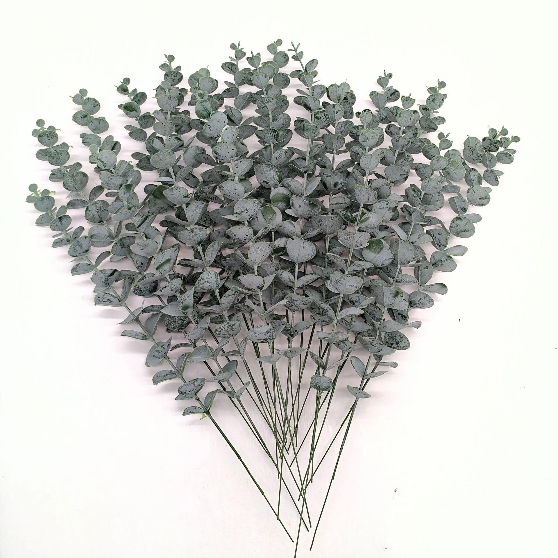 Bulk display of artificial baby silver dollar eucalyptus stems viewed from above