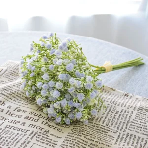 Light blue artificial baby's breath bouquet arranged on a newspaper backdrop