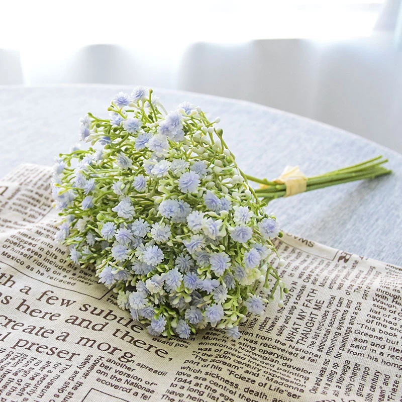 Light blue artificial baby's breath bouquet arranged on a newspaper backdrop