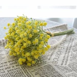 Yellow artificial baby's breath bouquet arranged on a newspaper backdrop