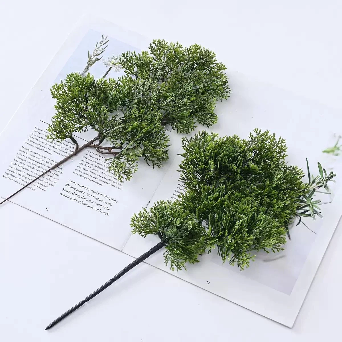 Layered-cloud and dense-cluster artificial bonsai stems in a styled display