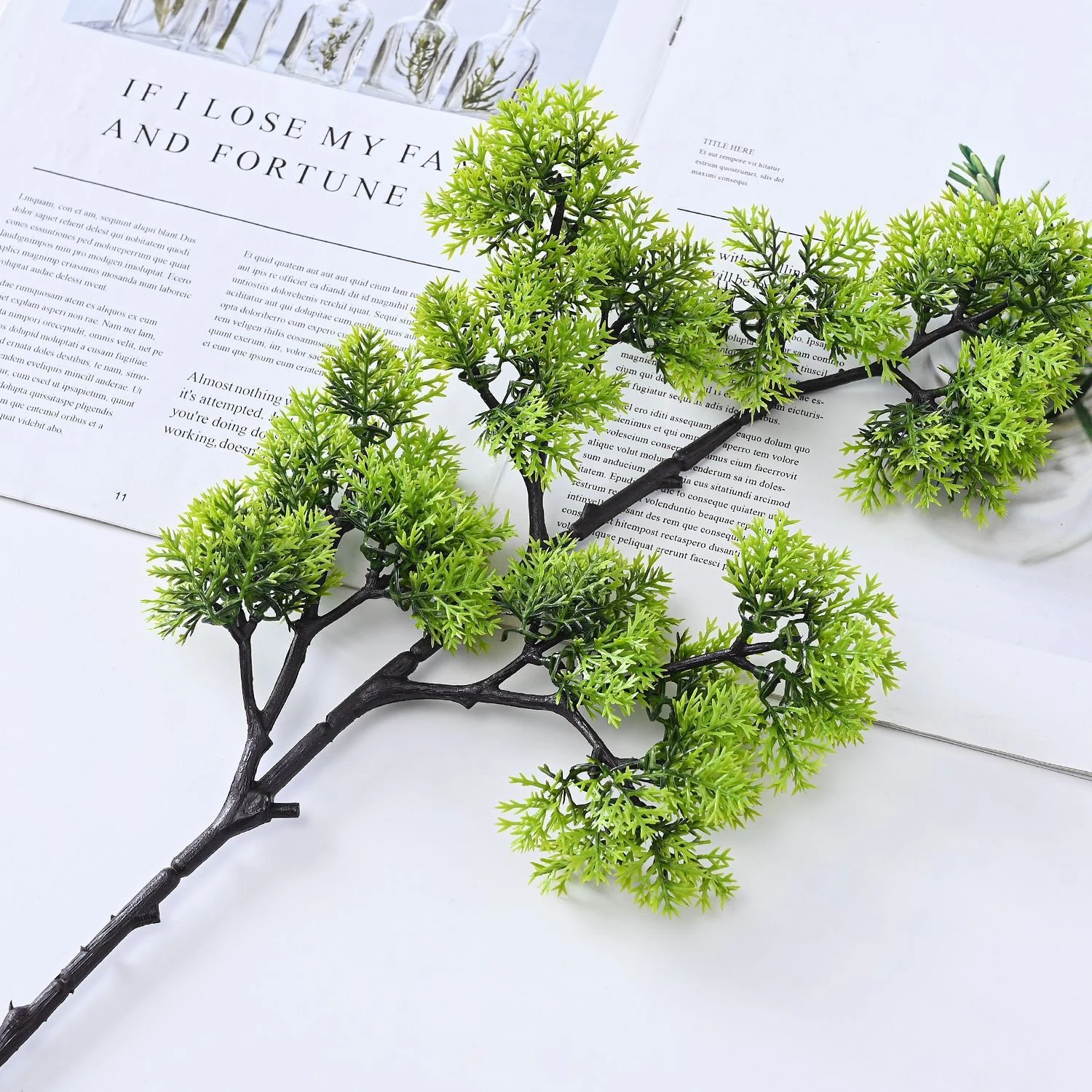 Rounded-cluster artificial bonsai stem arranged across an open book