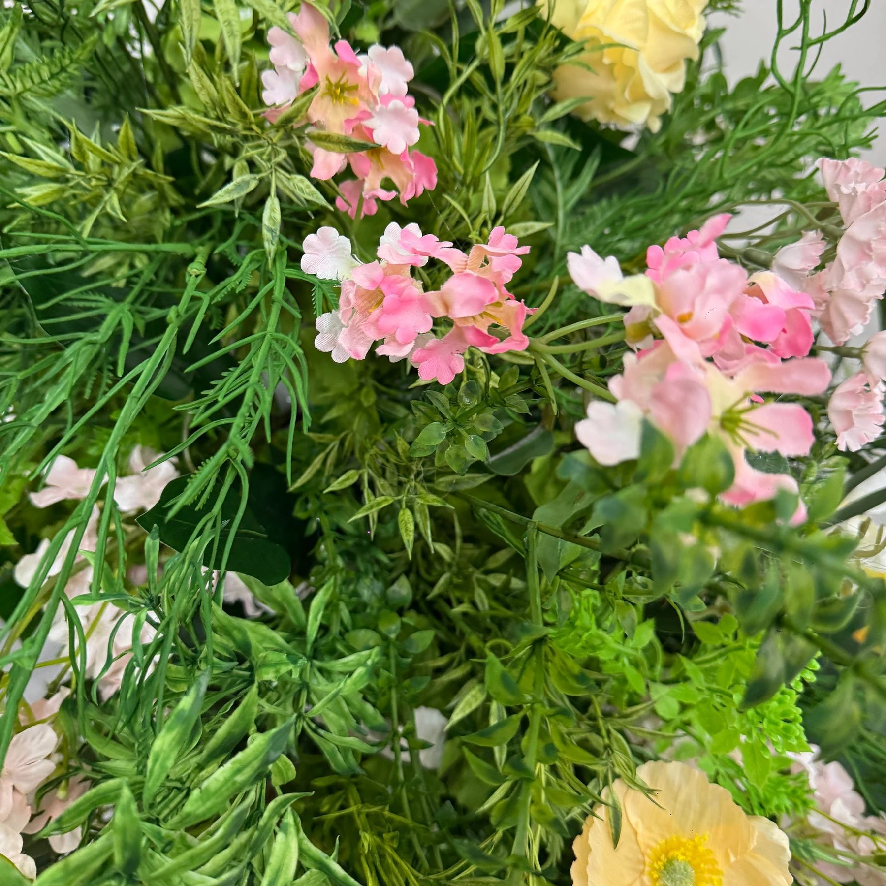 Close-up of pink artificial cascading wedding aisle flower arrangement
