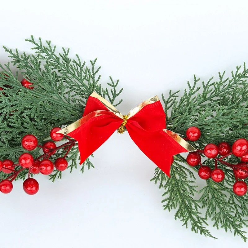 Red and gold bow detail on artificial cypress Christmas swag