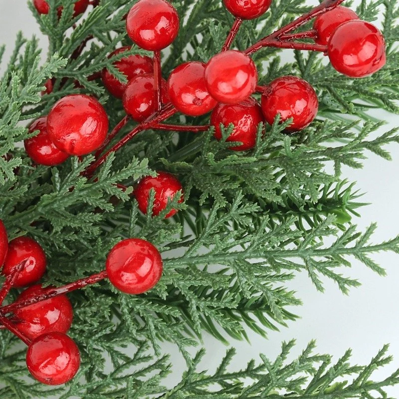 Close-up of cypress-style foliage and red berries on artificial Christmas swag