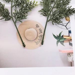 Pair of green artificial cypress branches in a styled decorative display