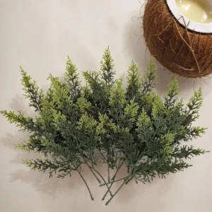 Multiple green artificial cypress branches arranged together