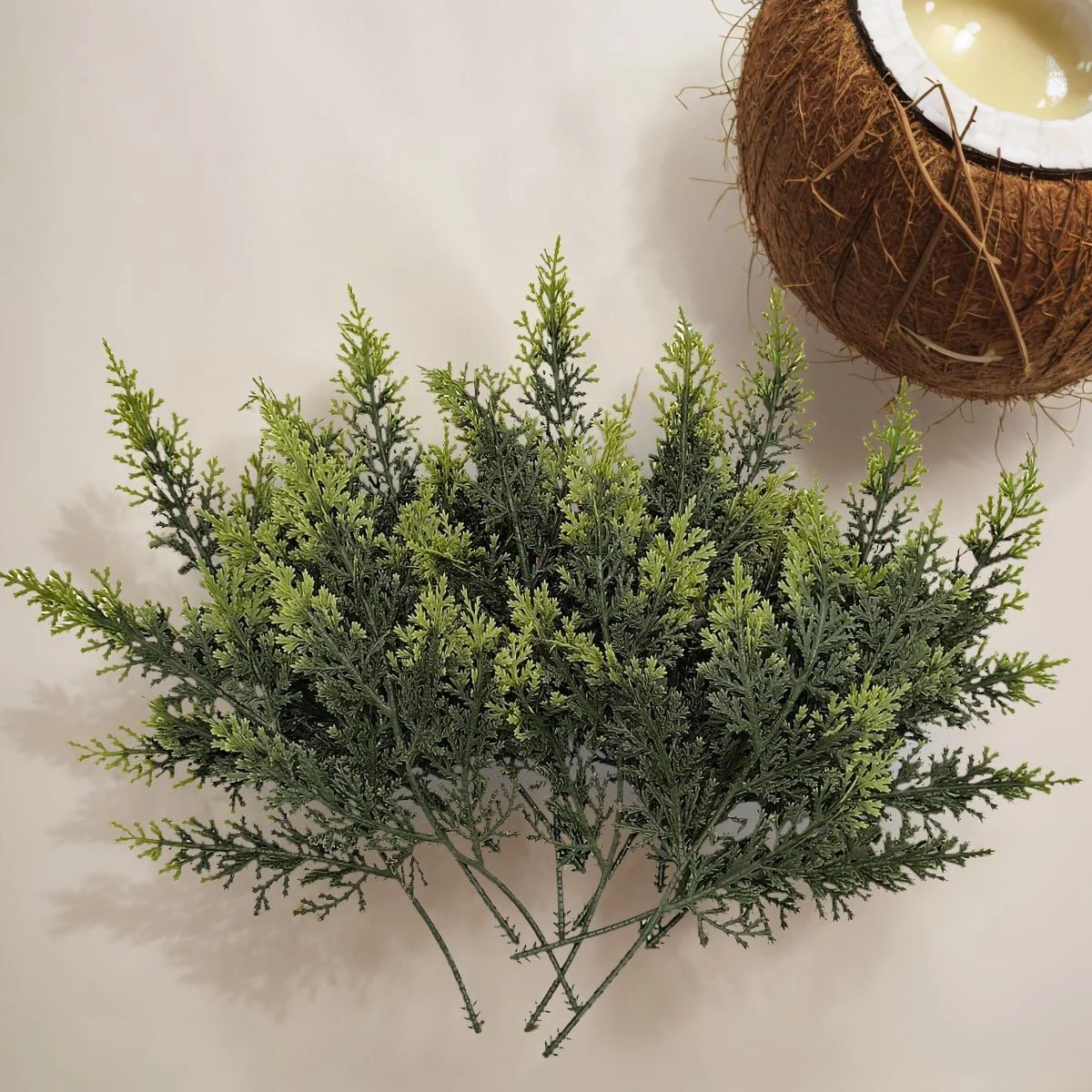 Multiple green artificial cypress branches arranged together