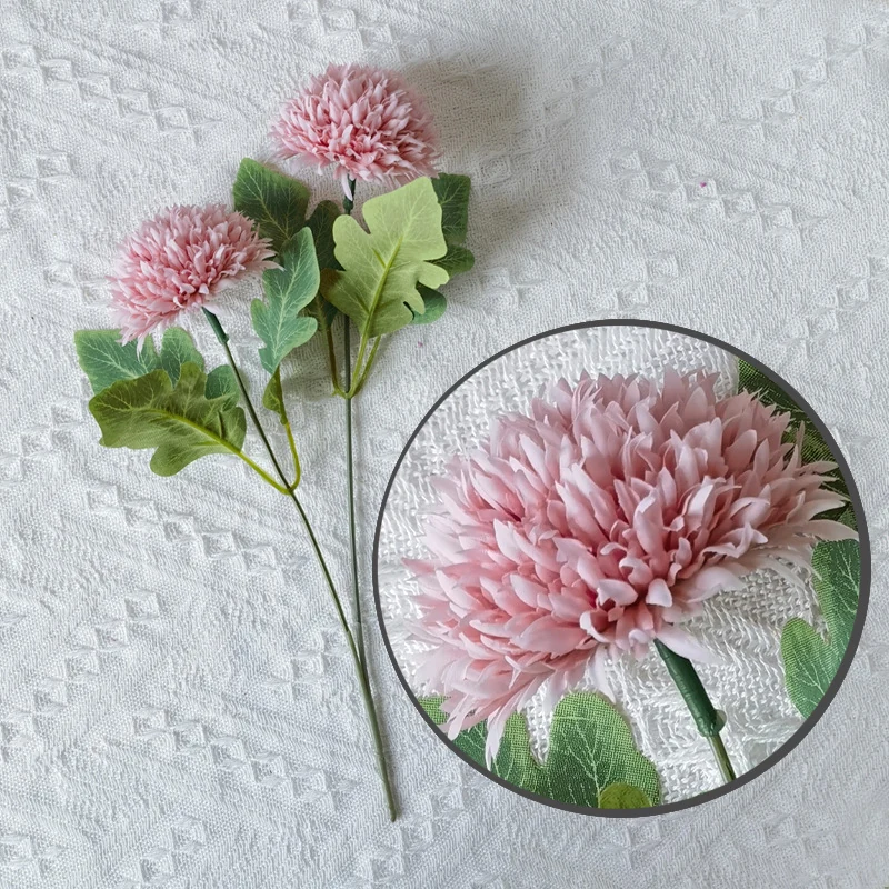Close-up of light purple pompon chrysanthemum flower heads and coordinating leaves