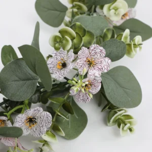 Close-up of white flowers and rounded eucalyptus leaves on artificial garland