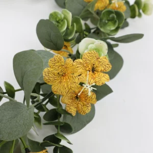 Close-up of yellow flowers and rounded eucalyptus leaves on artificial garland