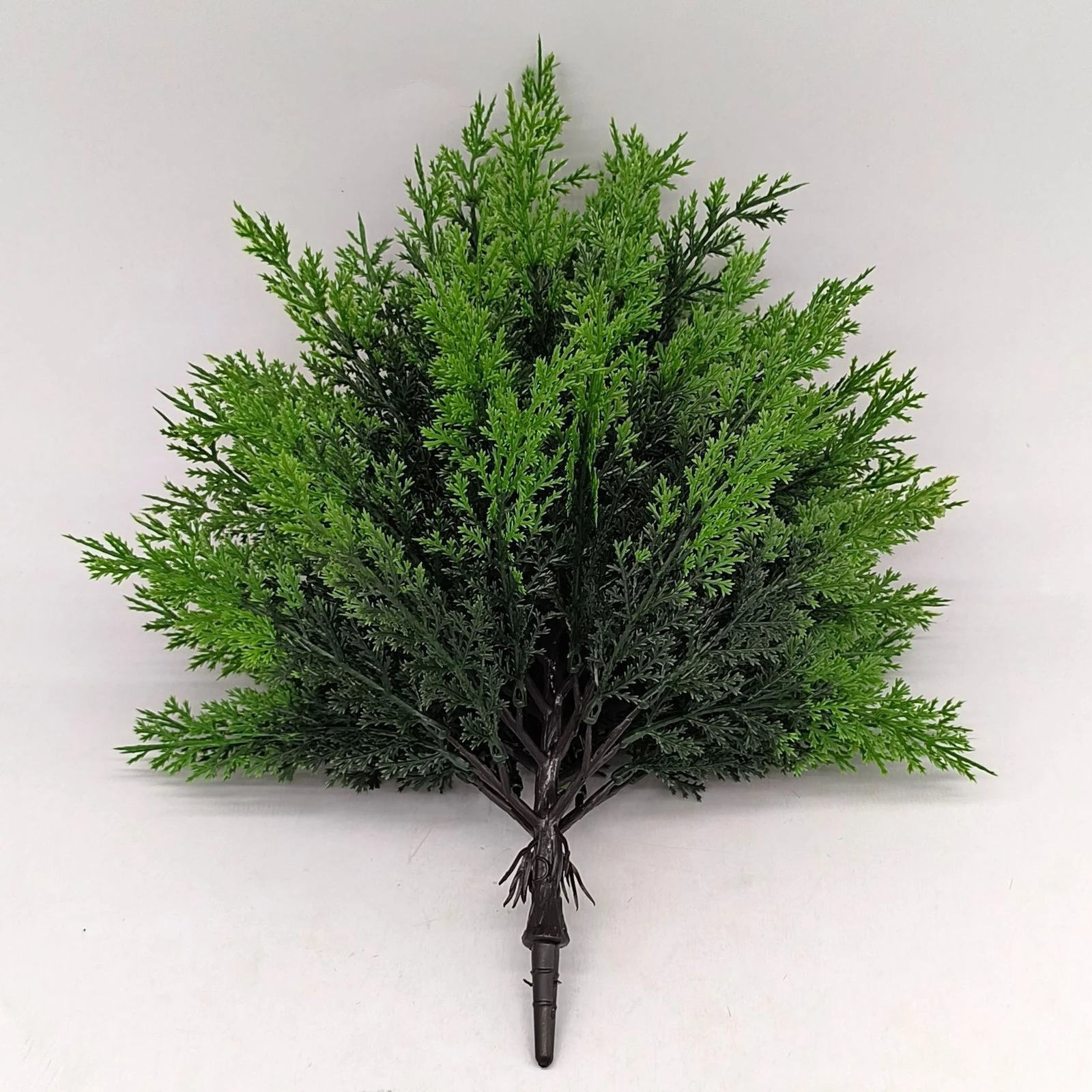 Front view of rounded artificial evergreen bush with dense green foliage
