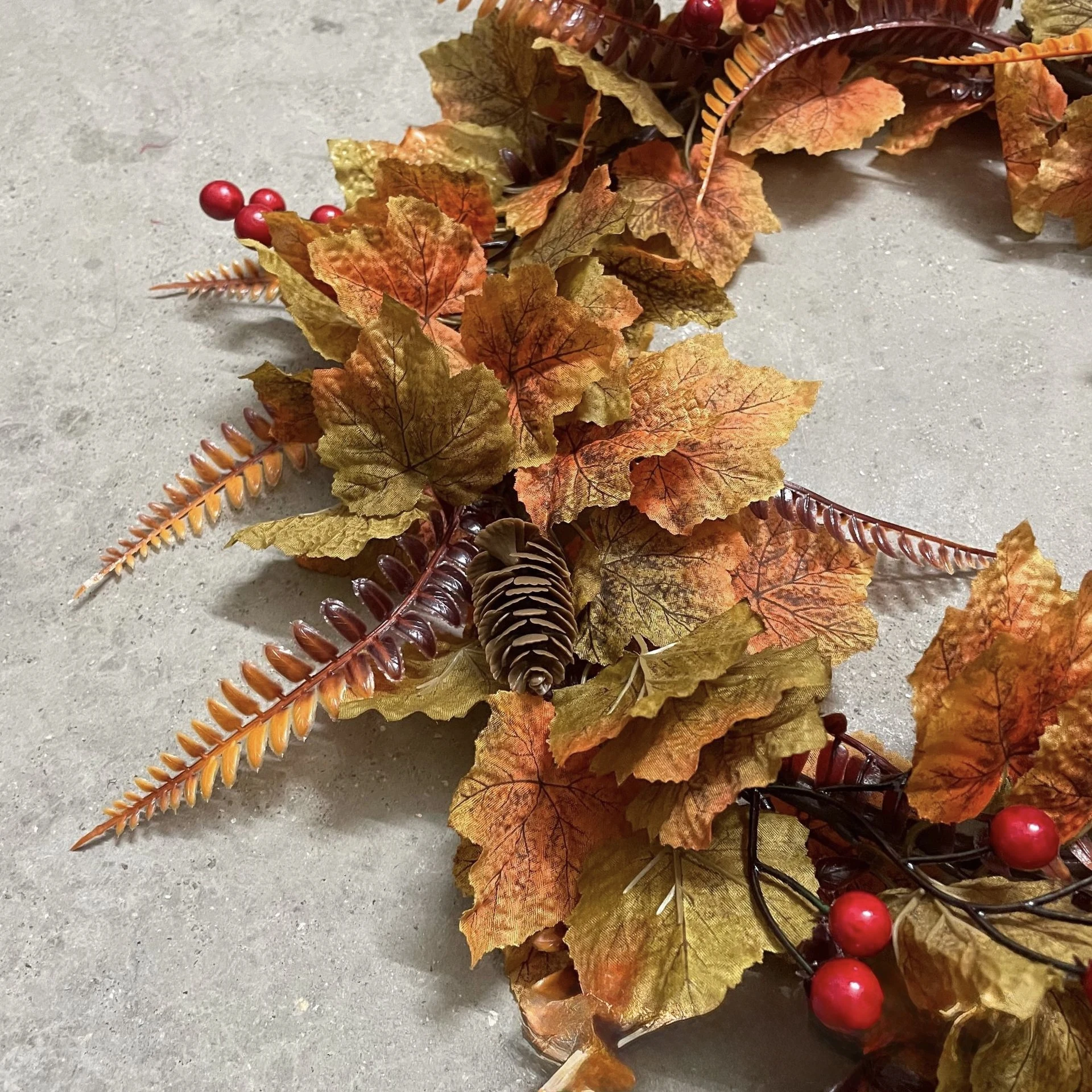 Close-up of textured maple-style leaves on artificial fall wreath