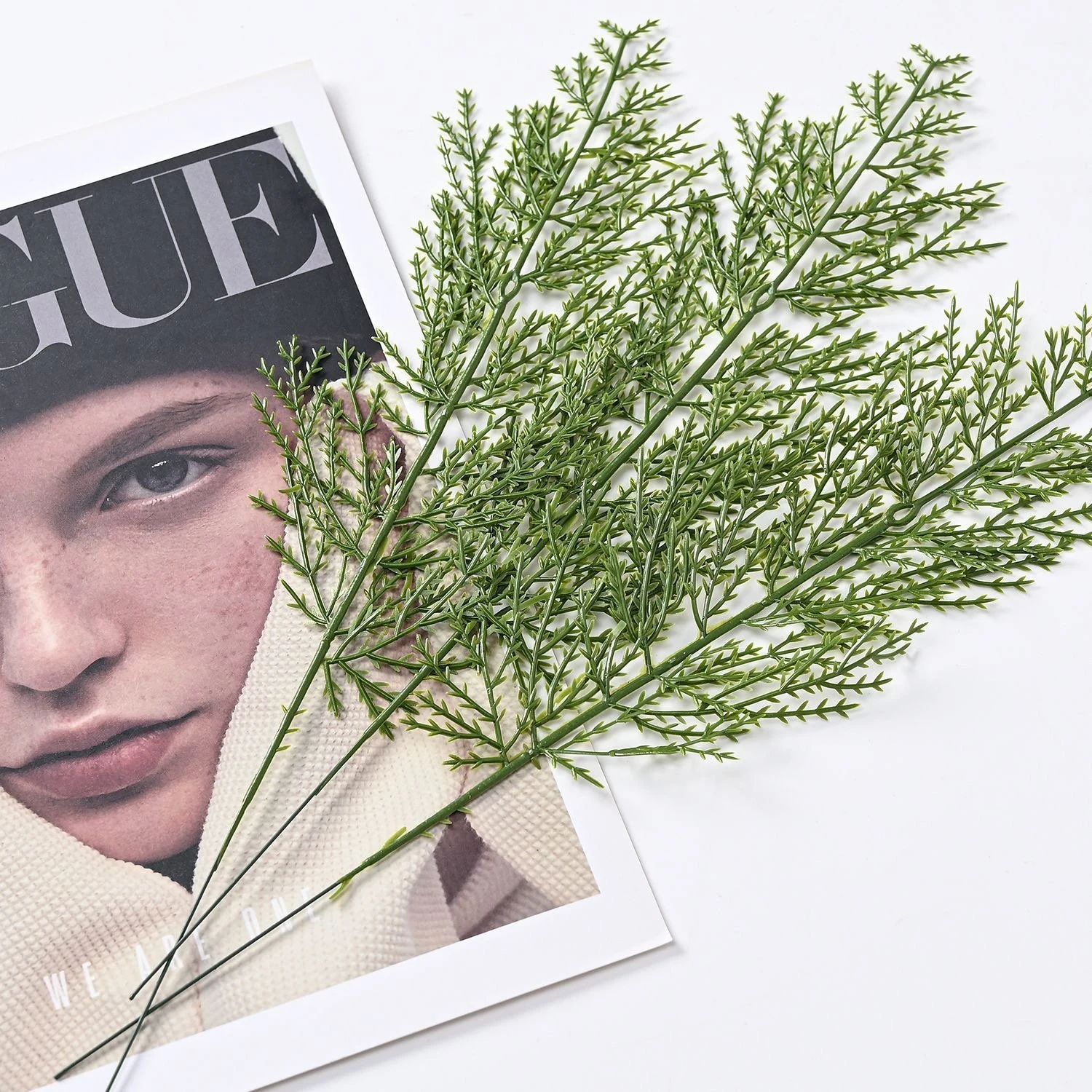 Multiple artificial flat cedar foliage sprays arranged in a layered display