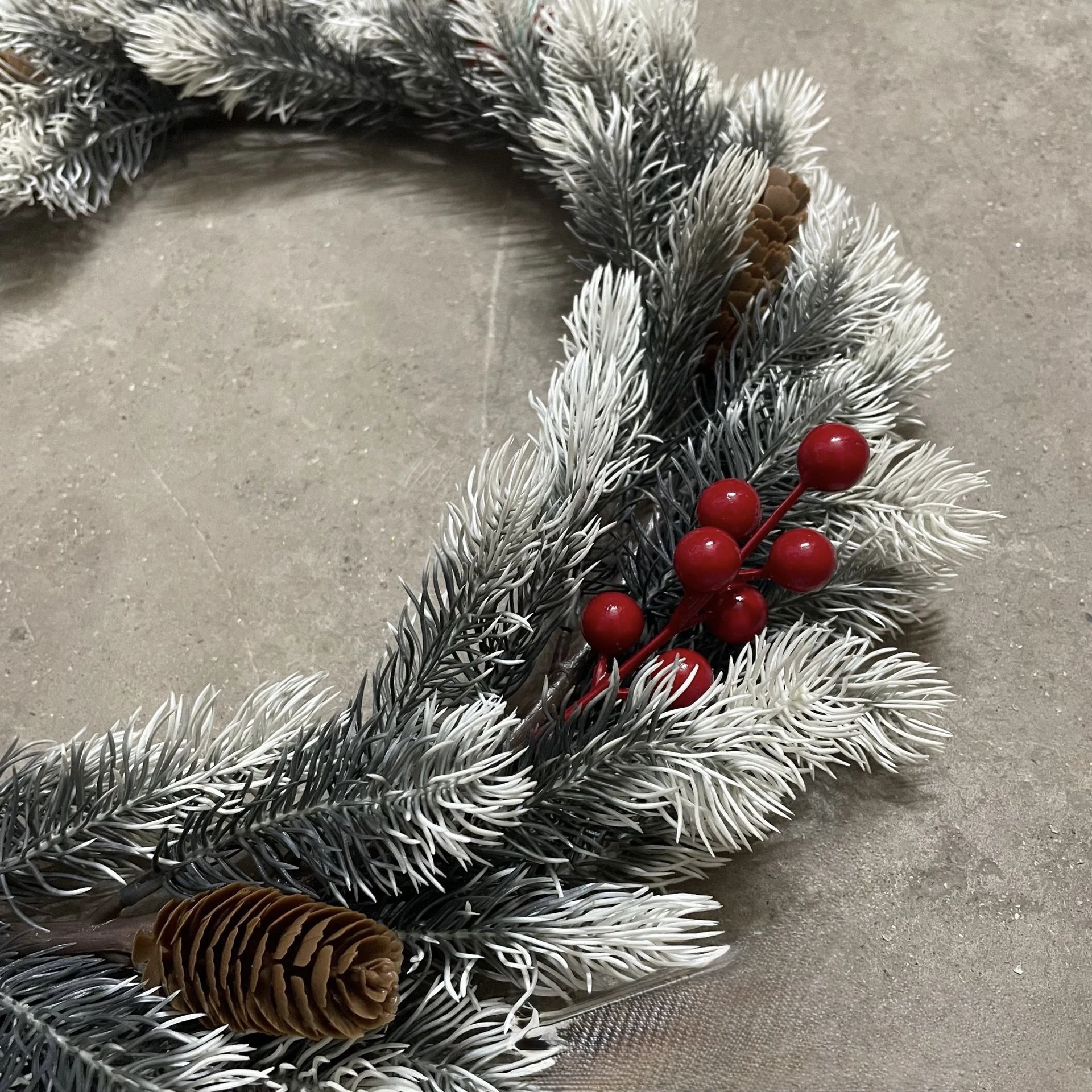 Close-up of pinecones and flocked fir foliage on wreath