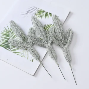 Three artificial frosted pine picks laid flat