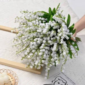 Handheld bouquet of white artificial lily of the valley stems