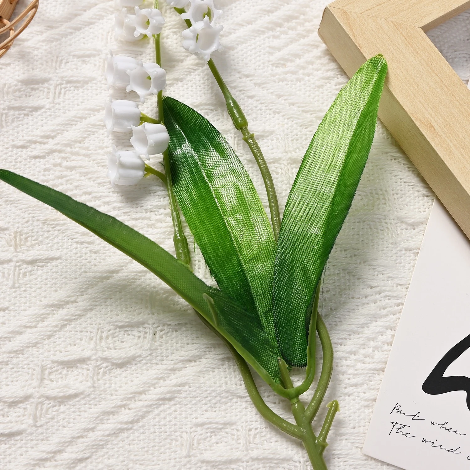 Close-up of green leaves on an artificial lily of the valley stem
