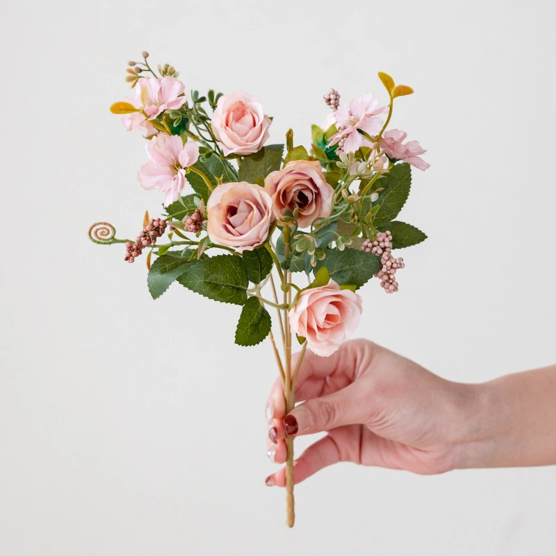 Handheld view of blush pink artificial mini rose mixed flower bouquet