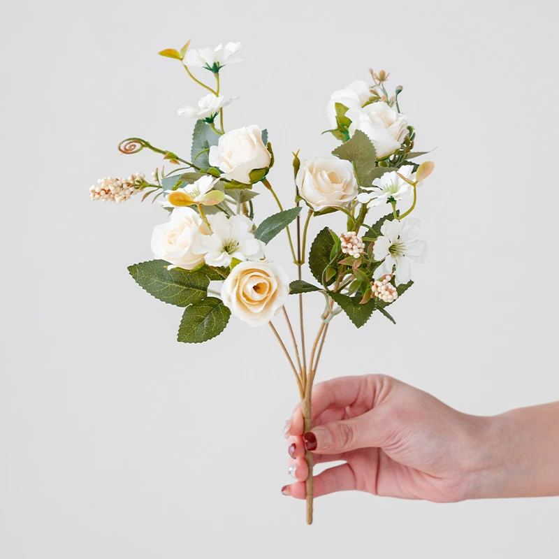 Handheld view of white artificial mini rose mixed flower bouquet