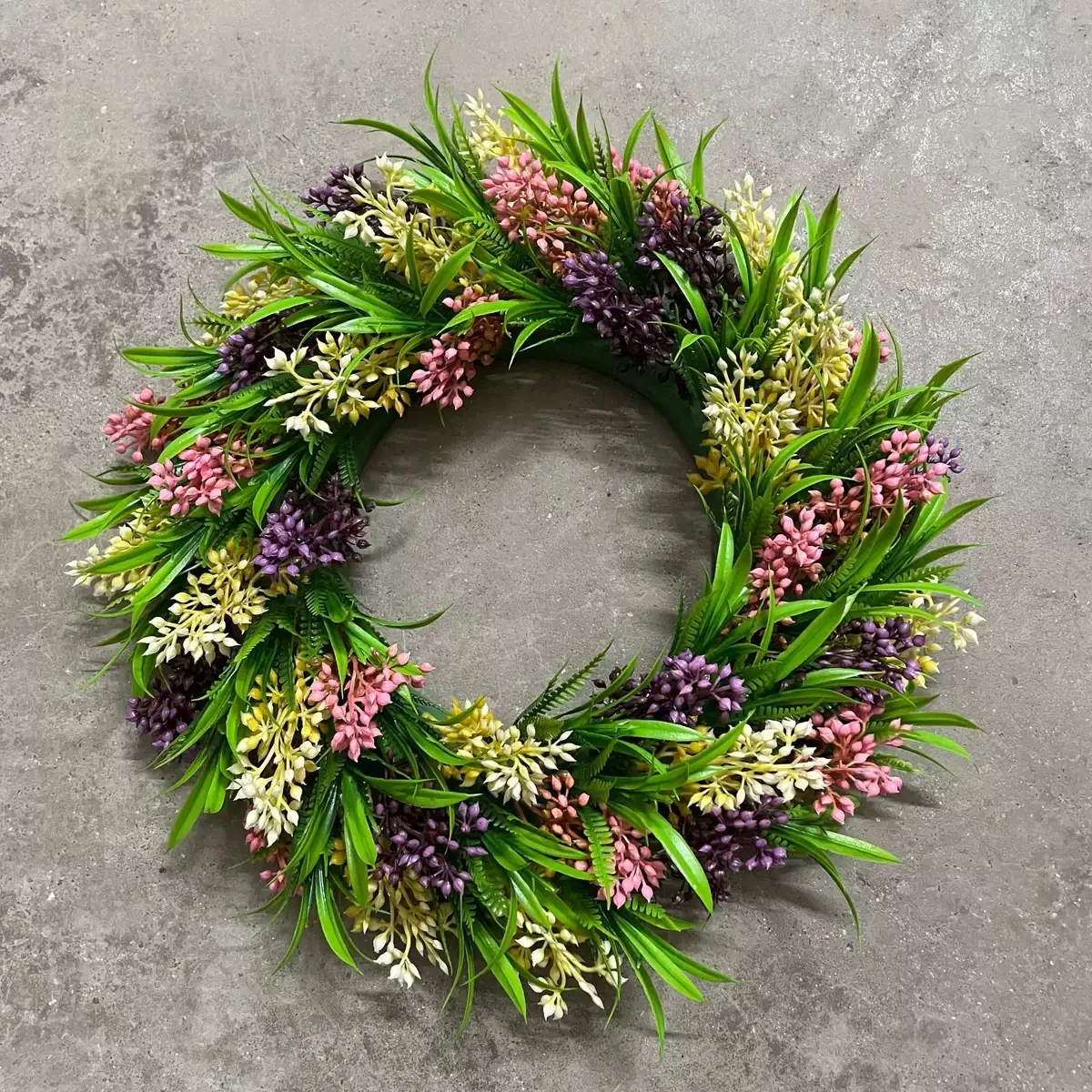 Top view of artificial mixed greenery wreath