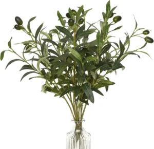 Artificial olive branches arranged in a clear glass vase