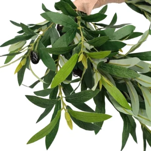Close-up of layered artificial olive leaves and fruit accents