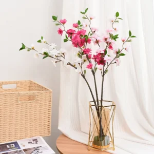 Rose pink, light pink and white artificial peach blossom branches in a vase