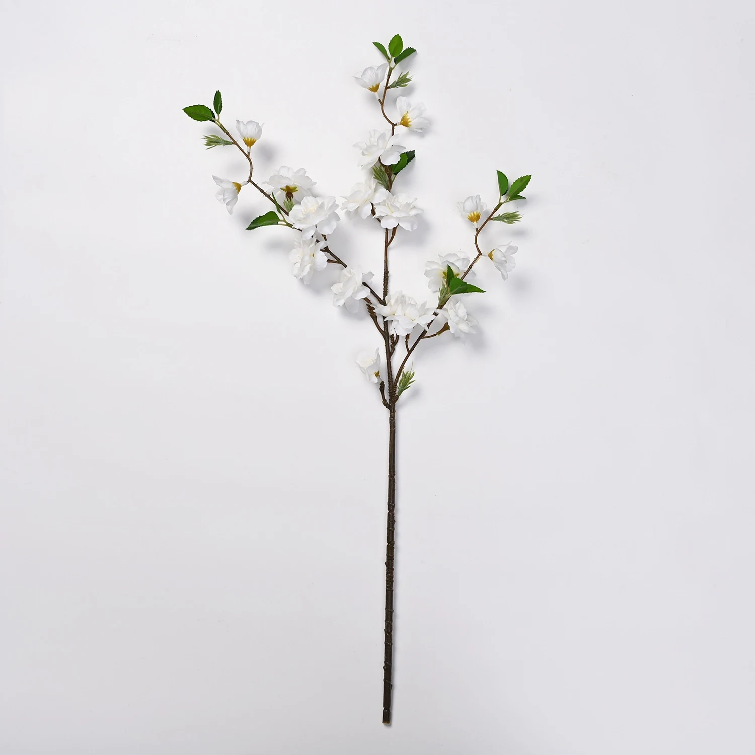 White artificial peach blossom branch on a white background