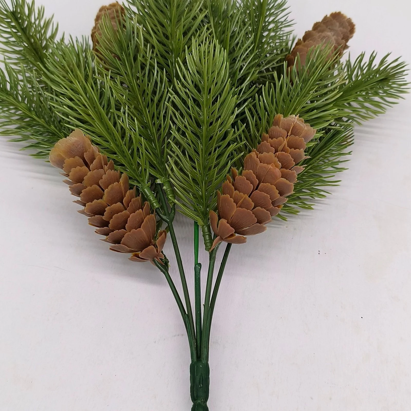 Close-up of pinecones and layered needles on artificial evergreen bush
