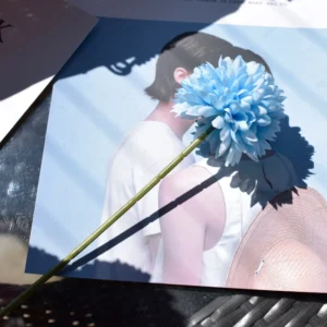 Blue artificial single-head pompon mum stem in a styled tabletop display