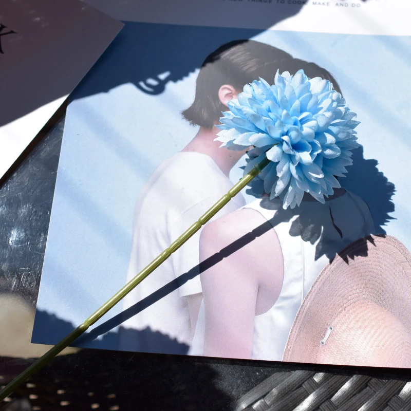 Blue artificial single-head pompon mum stem in a styled tabletop display