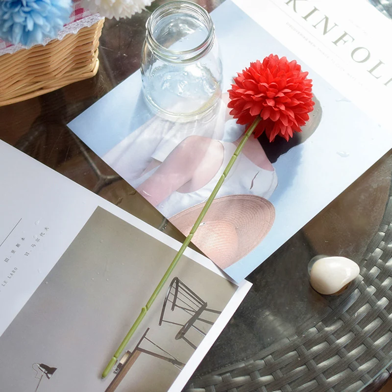 Red artificial pompon mum stem in a styled tabletop display