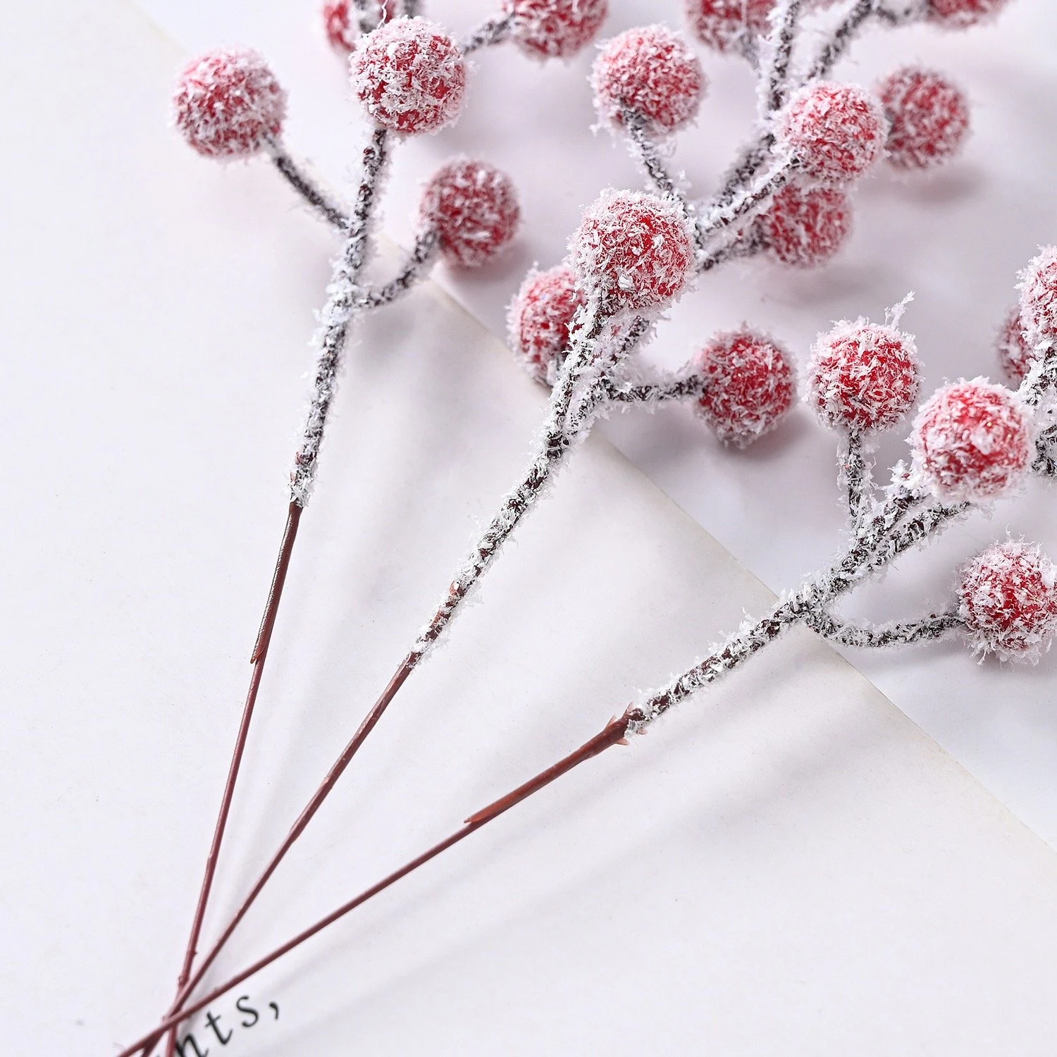 Close-up of snow-dusted flocking on artificial berry pick stems