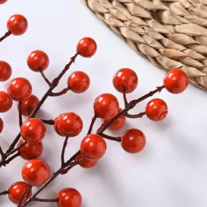 Close-up of glossy red berries on an artificial pick