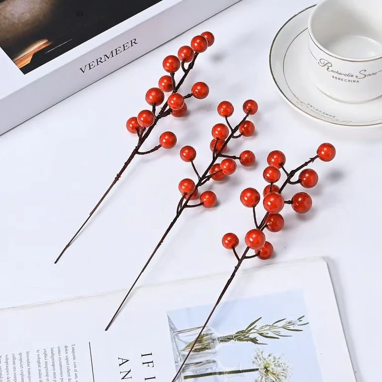 Glossy red artificial berry picks in a styled tabletop display