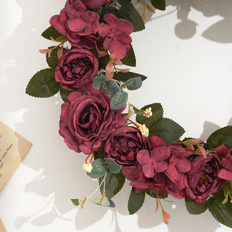 Close-up of red artificial roses and hydrangea flowers on wreath