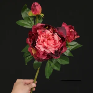 Handheld view of burgundy artificial three-head peony spray