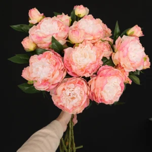 Handheld view of pink artificial three-head peony spray