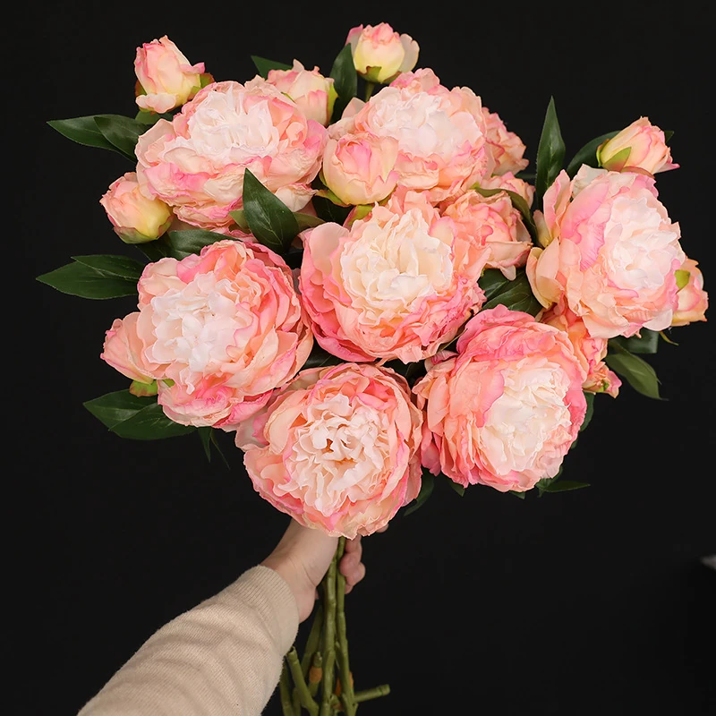 Handheld view of pink artificial three-head peony spray