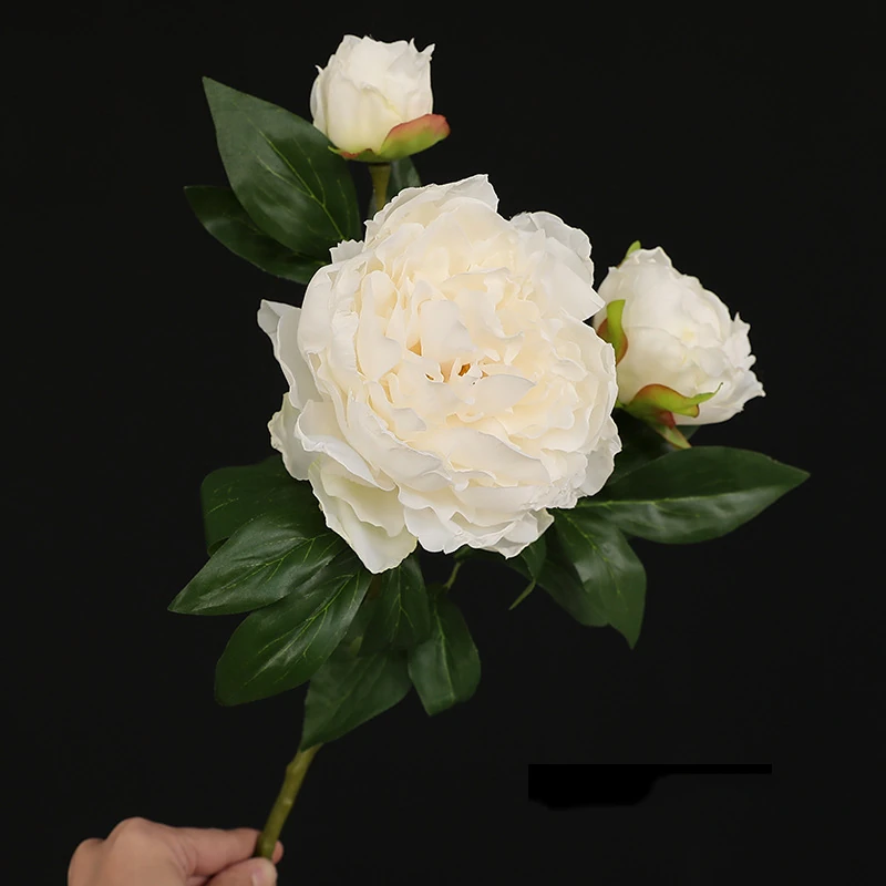 Handheld view of white artificial three-head peony spray