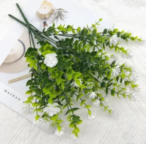 Artificial white mini flower bush in a styled flat-lay display