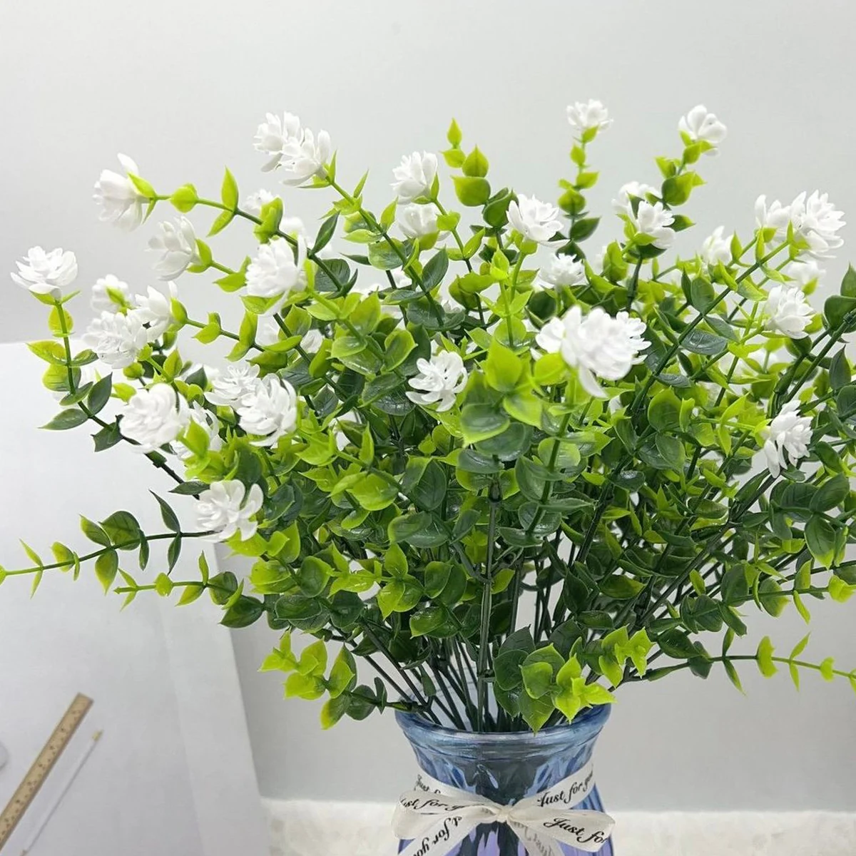 Artificial white mini flower bush arranged in a vase