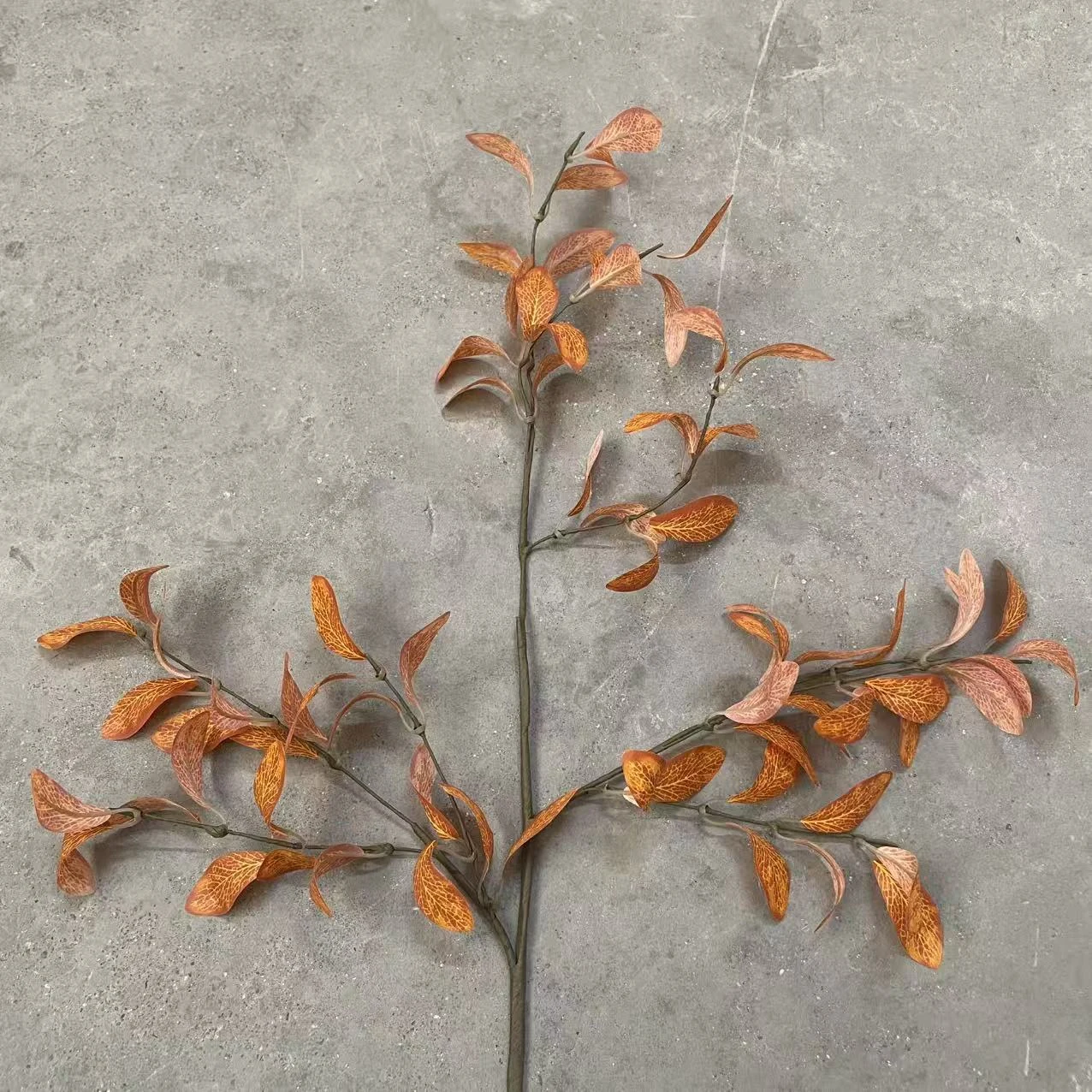 Spread view of burnt orange artificial eucalyptus spray branches