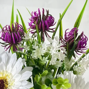 Close-up of purple potted artificial daisy mixed flower arrangement