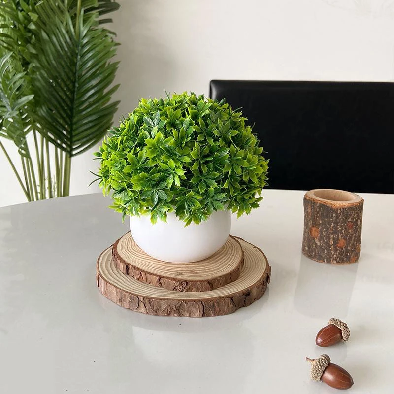 Mixed holly leaf potted artificial greenery topiary ball in a tabletop setting