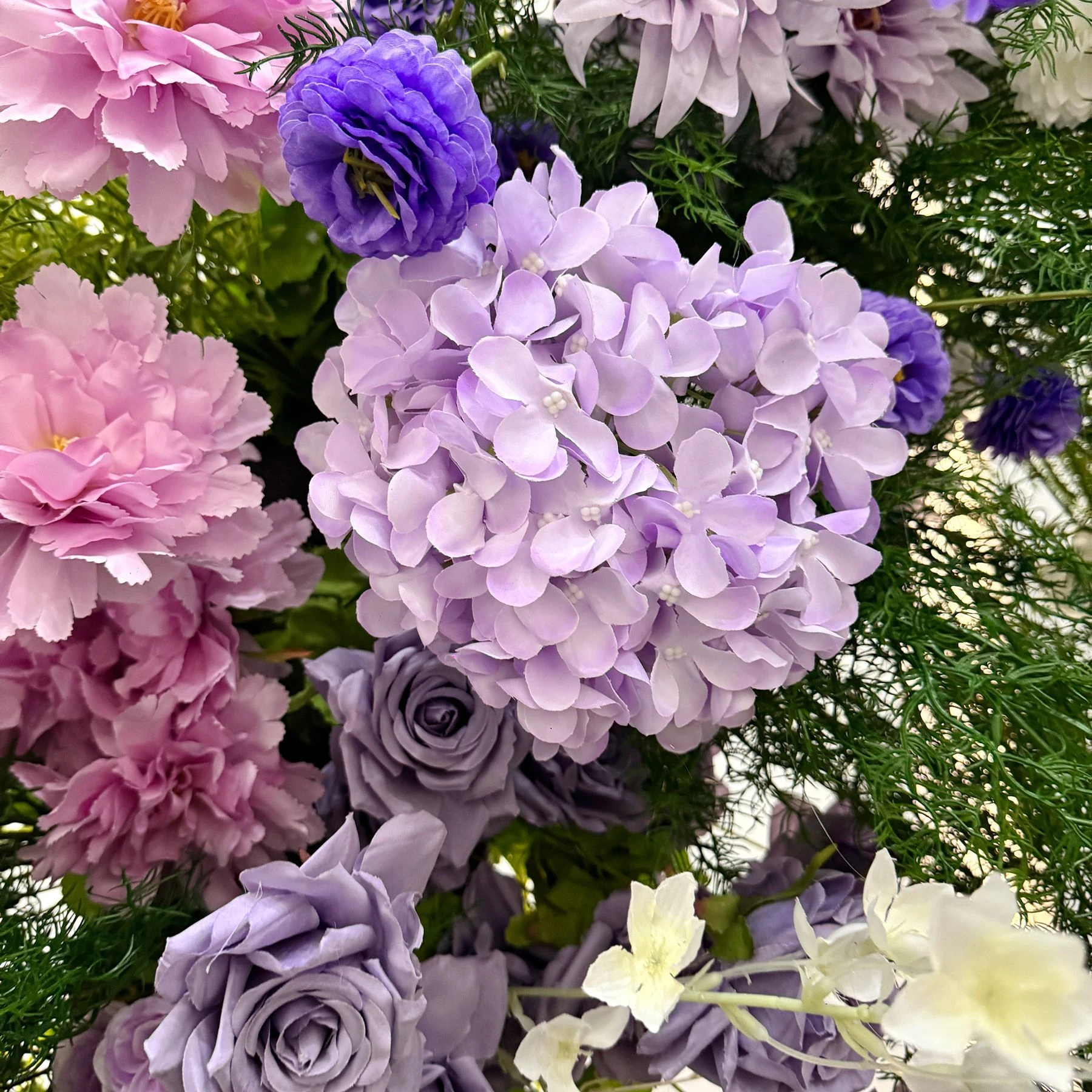 Close-up of purple hydrangea rose wedding flower arch