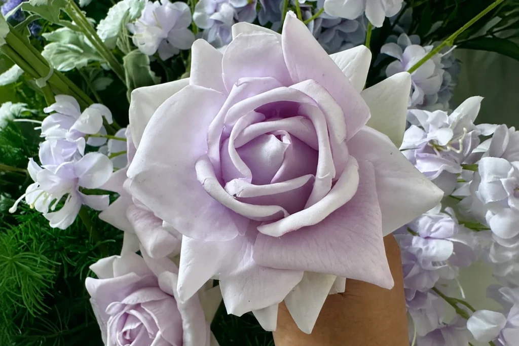 Close-up of a pale lilac artificial rose showing layered petals and subtle surface texture.