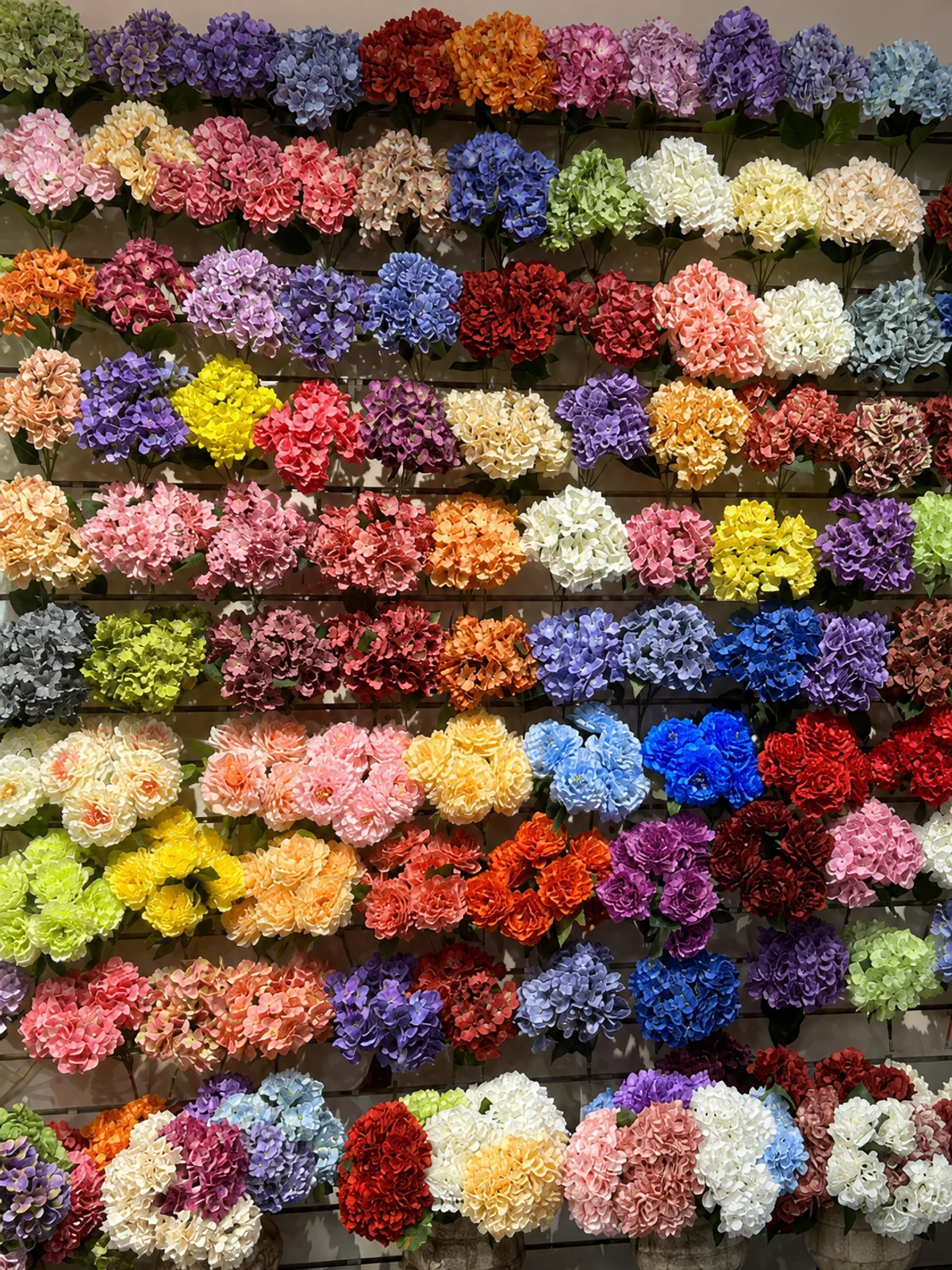 Pink, blue, purple, green and cream artificial hydrangeas displayed in the PJTL showroom.